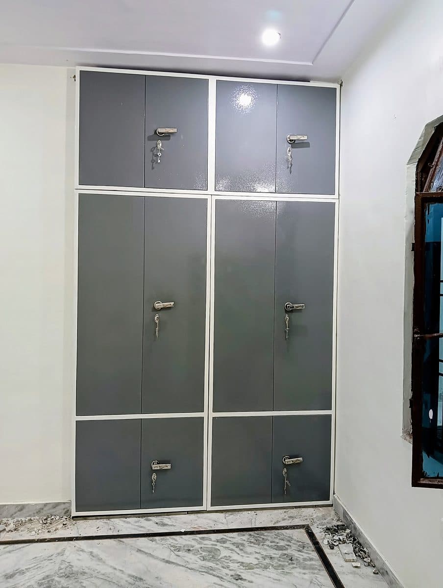 दीवार की अलमारी पर लगे ग्रे स्टील गेट, ऊपर और नीचे के खानों के साथ