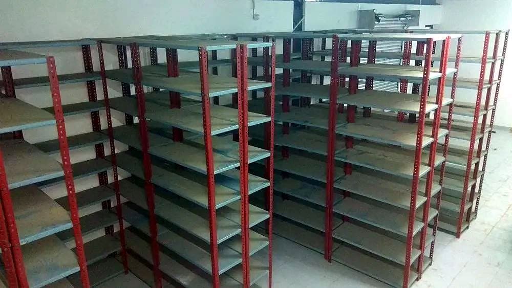 गोदाम में लाल-ग्रे स्टील रैक की कतारें